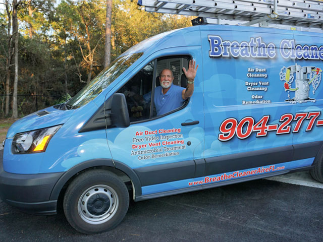 air duct cleaning company owner poses for photo in company truck